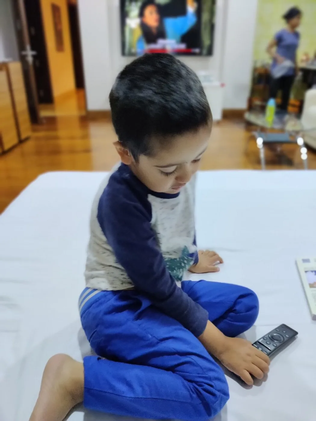 A young child intently studying a remote control—everyday curiosity that schools often miss