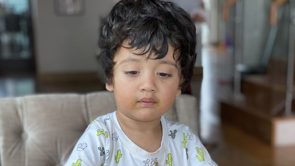 A young boy looking down, quiet and absorbed in his own thoughts
